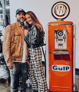 Couple posing beside an orange Gulf replica gas pump